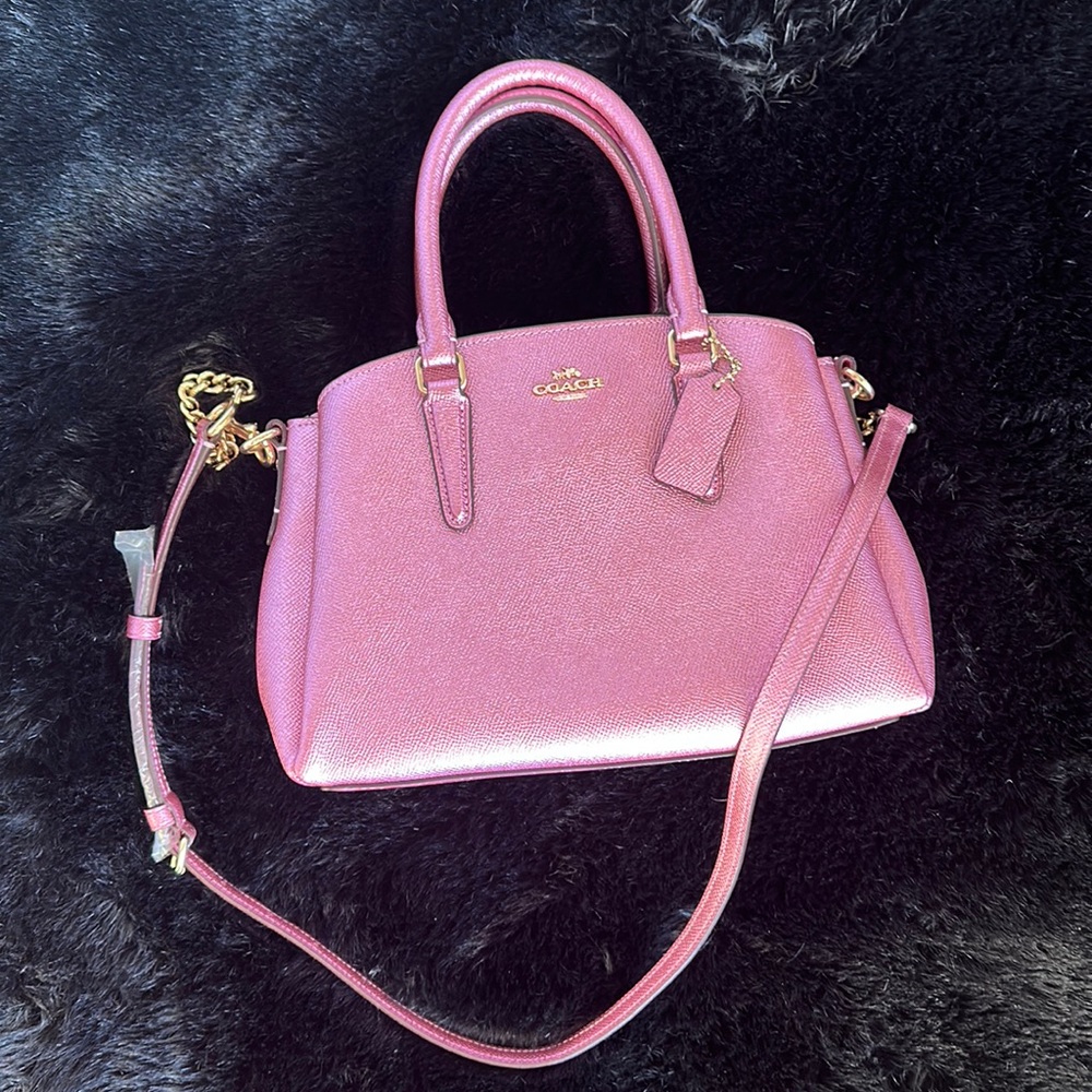 Metallic pink Coach purse with gold chain accent strap.